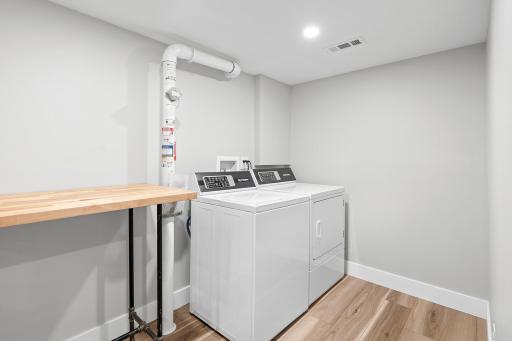 Dedicated lower level laundry zone includes Speed Queen washer and dryer, sink and radon mitigation system.