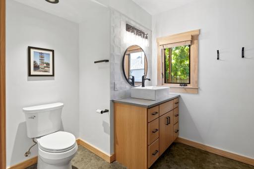Main level bathroom has been completely renovated from top to bottom. Expanded floorplan affords thoughtful storage, a beautiful vanity and gorgeous tile shower.