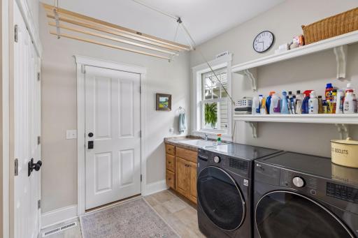 Main-floor laundry with practical storage, workspace, and full-size appliances.
