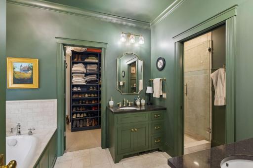 The primary bath continues the rich green palette with custom cabinetry and thoughtful details.