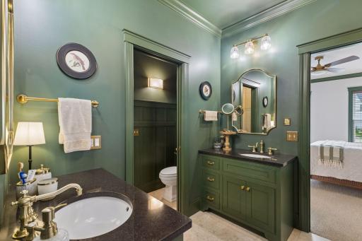 A refined primary bath with double vanity, brass accents, and generous storage.