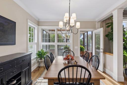 The dining area is surrounded by natural light and positioned just off the screen porch.