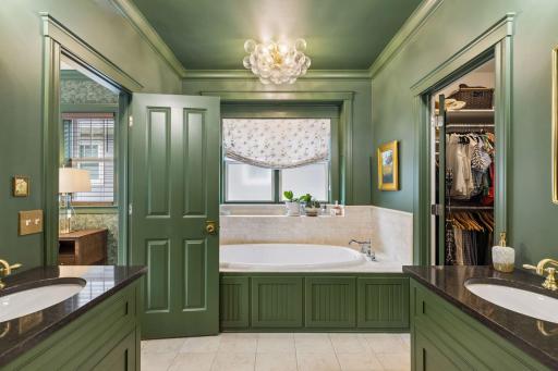 Soaking tub, custom cabinetry, and warm finishes create a beautifully composed primary bath.