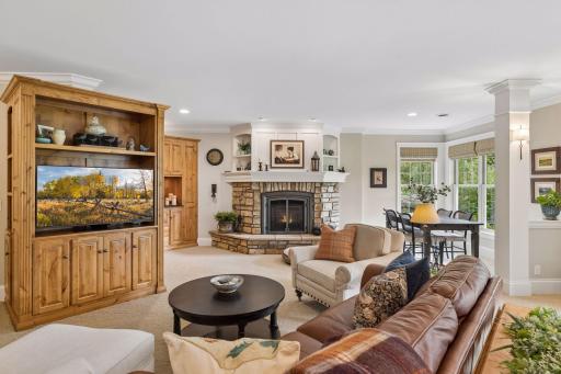 Built-ins, a second stone fireplace, and abundant natural light define the lower-level family room.