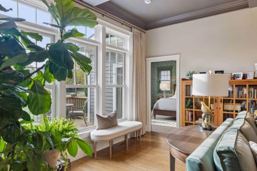 A sun-filled corner of the living room with windows overlooking the beautifully landscaped setting.