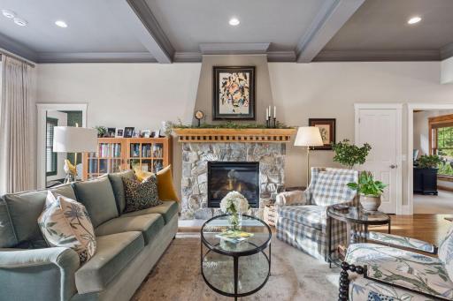 Coffered ceilings, crown molding, and a real stone fireplace give the living room beautiful character.