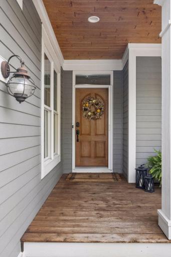 A charming covered entry with warm wood details and a front door that sets the tone inside.
