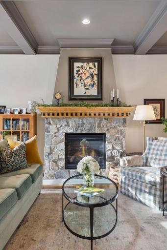 The stone fireplace anchors the living room while the kitchen remains just steps away.