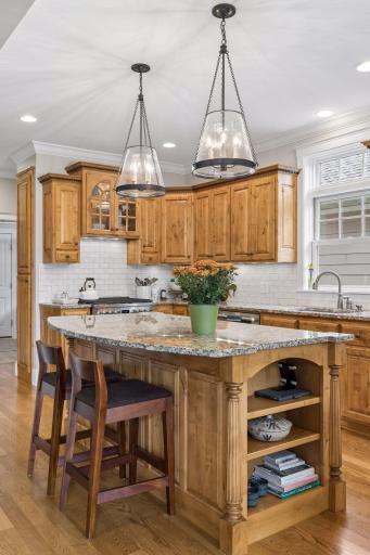 Granite surfaces, stainless appliances, and abundant cabinetry make the kitchen as functional as it is inviting.