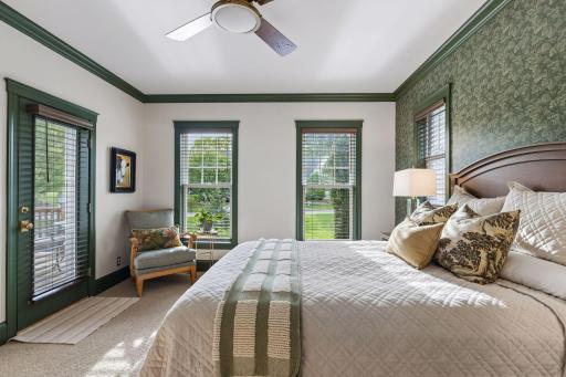 Another view of the main-floor primary suite, filled with natural light from multiple exposures.