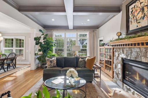Natural light fills the main living room, framed by hardwood floors and views toward the backyard.