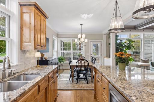 The kitchen looks directly toward the dining area and windows beyond.