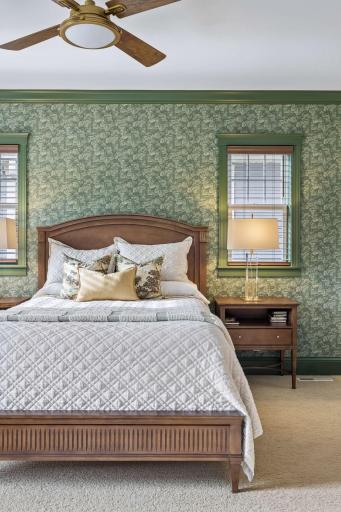 The main-floor primary bedroom combines warm finishes, natural light, and generous space.