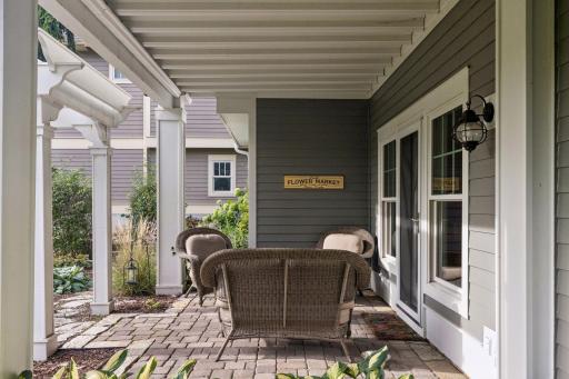 A protected outdoor seating area extends the living space into the landscaped surroundings.