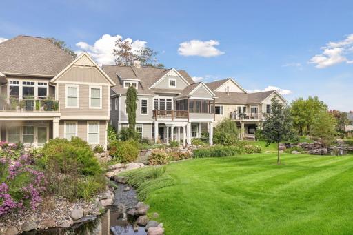Rear views showcase the homeâs relationship to the landscaped green space and water.