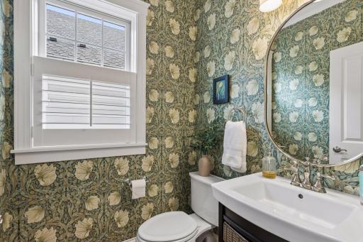 A charming powder bath with patterned wallcovering and classic finishes.