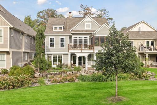 A full rear view highlights the screen porch, deck, patio, and walkout lower level.