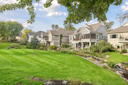 Beautiful neighborhood landscaping gives the rear of the home a park-like setting.