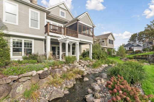 Stonework, mature plantings, and moving water create a beautiful setting just outside the home.