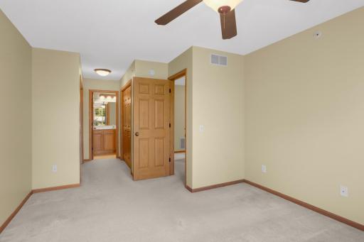 Another view of the primary bedroom walking towards two closets and the full bathroom.