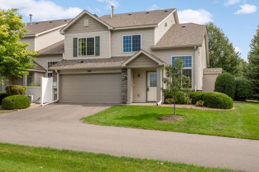 Bright and inviting south- and west-facing end-unit townhouse with grassy area on the side and in front of the driveway.