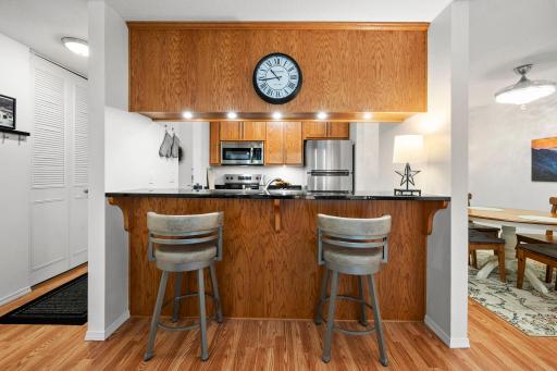 Beautifully updated kitchen with granite counters, Custom cabinetry, stainless steel appliances and a breakfast bar open to living area