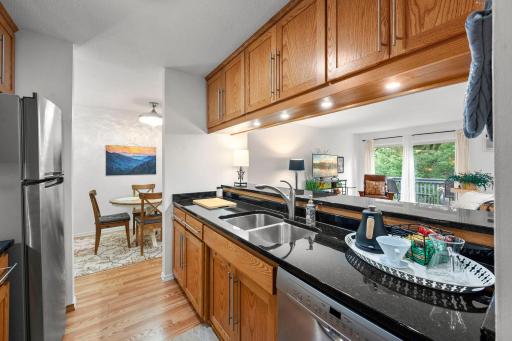 Lovely updated kitchen with granite counters, Custom cabinetry, stainless steel appliances and a breakfast bar open to living area,