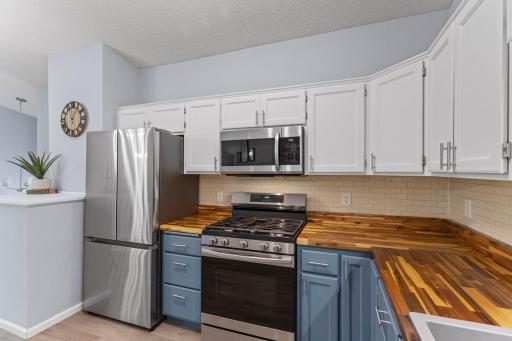Butcher block countertops and a tile backsplash complete the kitchen.