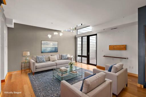 Living area opens to large, private deck. Painting credit provided. Virtually staged photo