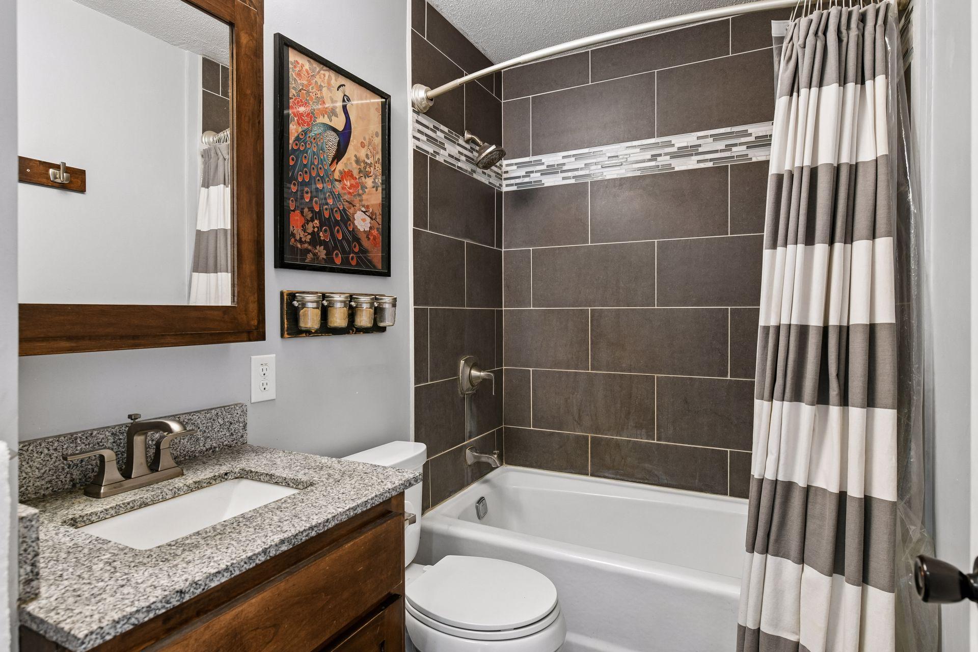 Full bath with tub shower combination and tile surround
