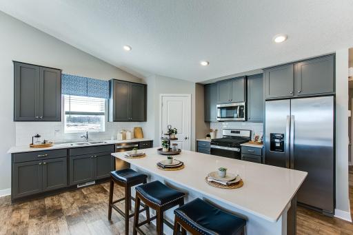 Kitchen highlights include stainless steel appliances, tiled backsplash and quartz countertops.