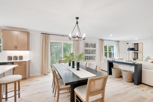 Open concept kitchen, dining, and family room give the home a light and airy feeling. Actual home features an additional morning room off the dining area! Photo of model home, finishes may vary.