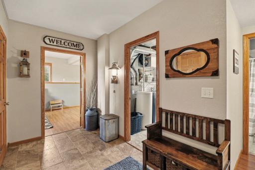 Hall at bottom of staircase is spacious with placement for a bench coming in from the garage.