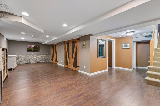Spacious lower level family room with adjacent half bath and plenty of storage.