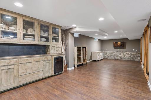 Shared lower level family room with TV, beverage frig, and cabinetry.