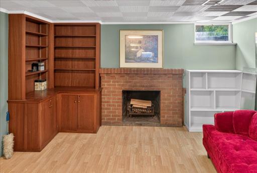 Classic wood burning fireplace with brick surround in the lower level rec room.
