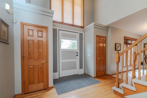 Enter the main floor via the large, custom front door into the foyer with an open staircase to the second floor.