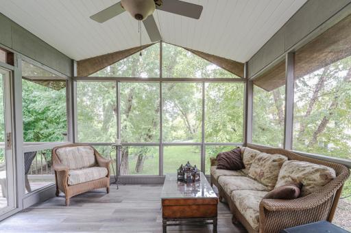 The vaulted screen porch lies off the kitchen and takes in beautiful greenspace views.