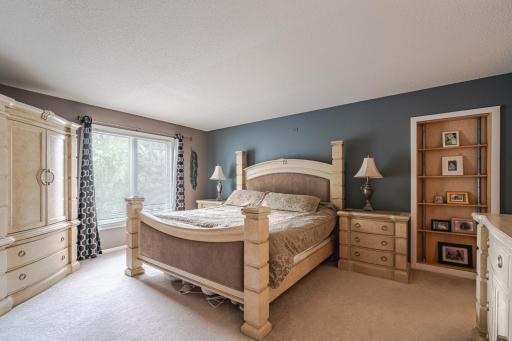 The laundry room has plank vinyl flooring, a bright window and stainless steel washer/dryer. The suite includes a walk-in closet with organizers, plus a second closet/secret room behind a hidden door.