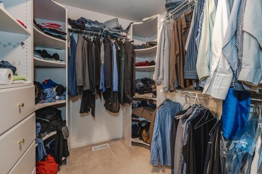 The walk-in closet has a closet organizer system.