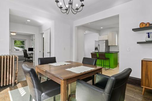 Dining room opens to the kitchen, adjacent hallway powder room and beyond is a main floor bedroom or office.