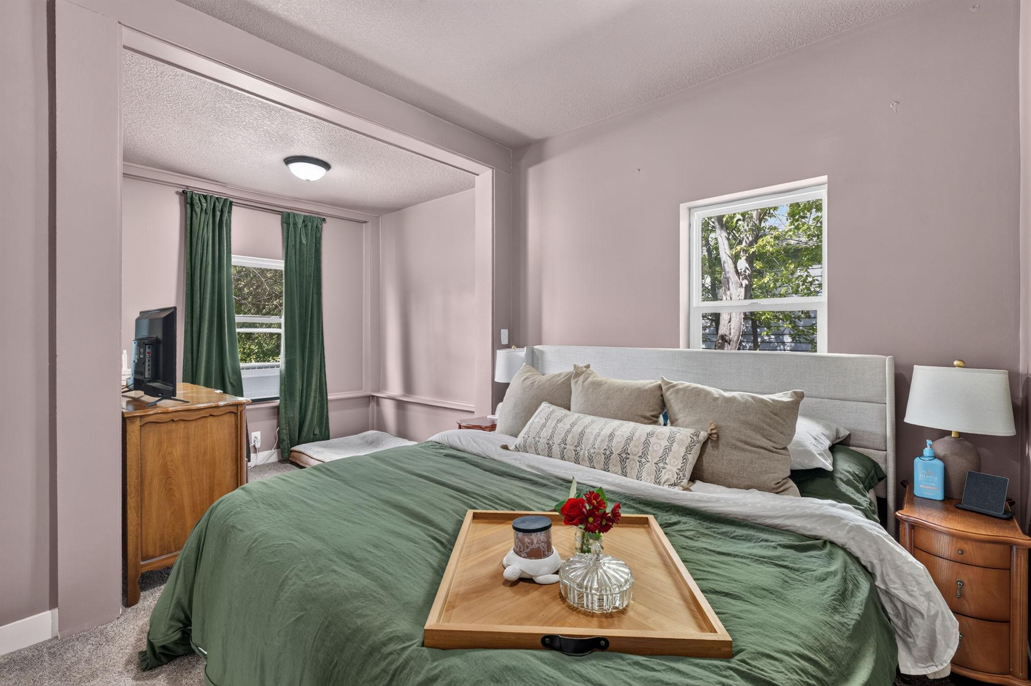 Light-filled primary bedroom featuring newer carpet and a peaceful atmosphere.