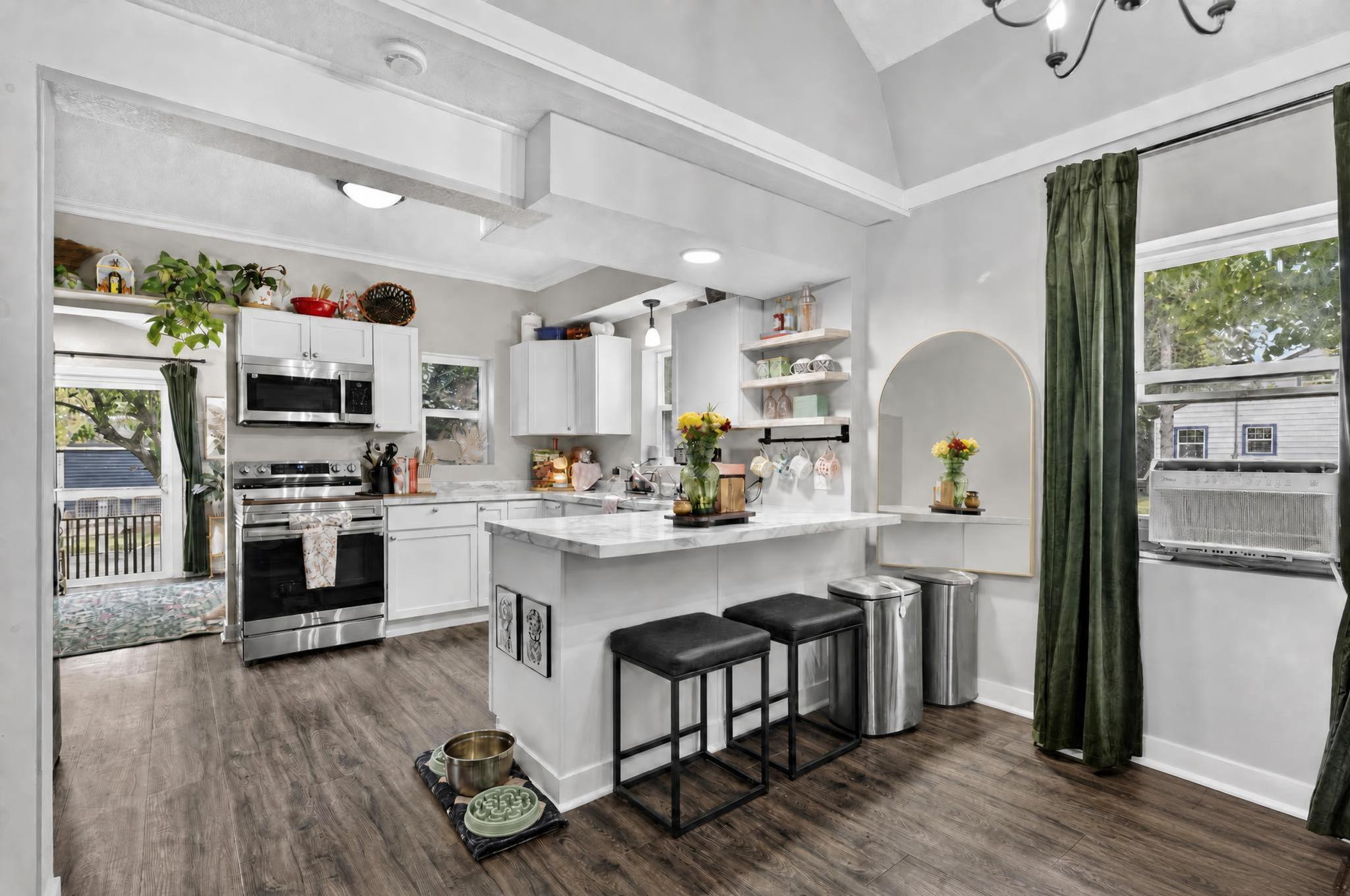 Open-concept kitchen and dining area featuring breakfast bar seating, abundant natural light, and a seamless flow for everyday living and entertaining.