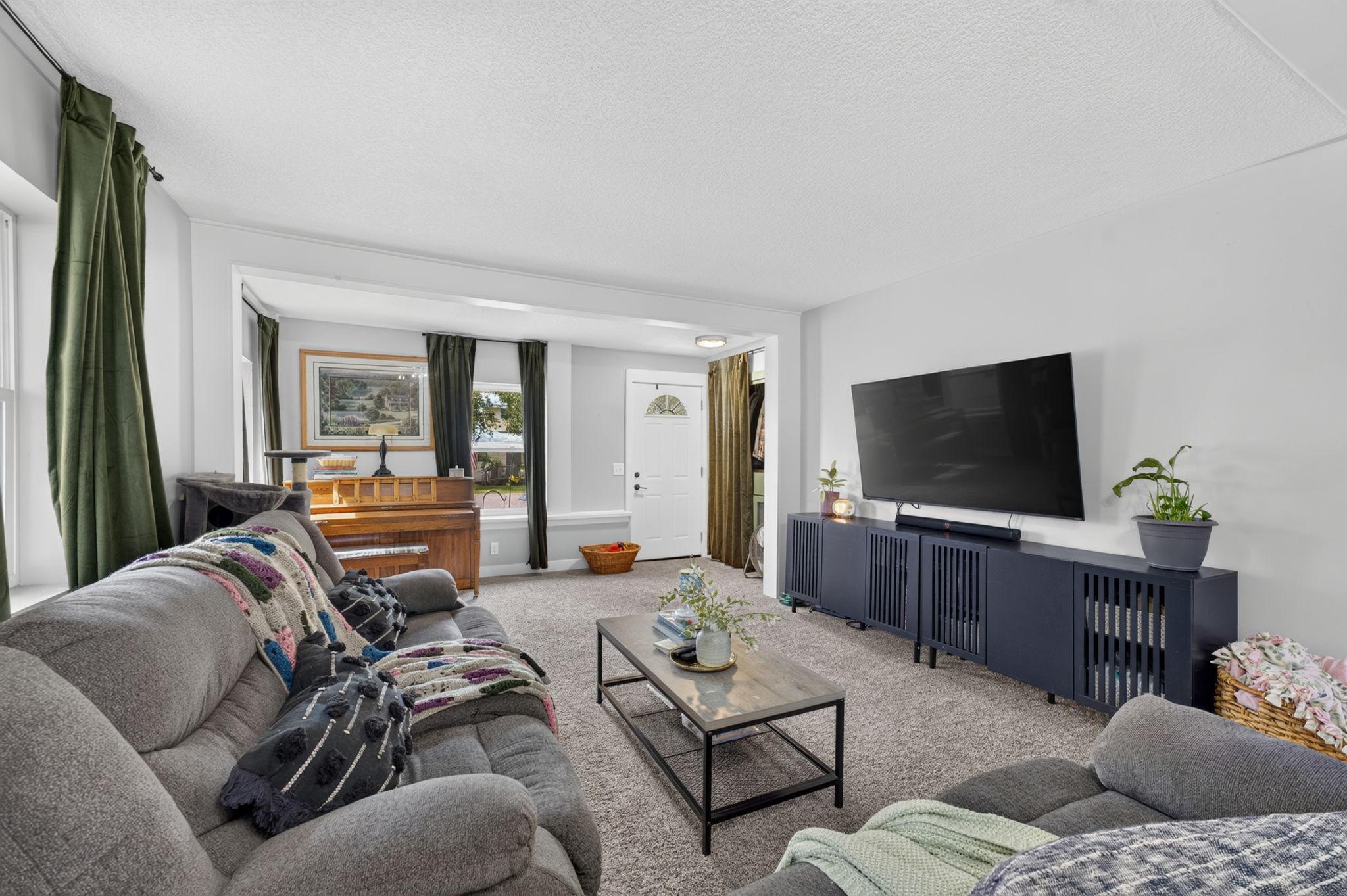 Comfortable living room offering generous space, new carpet, and plenty of natural light.