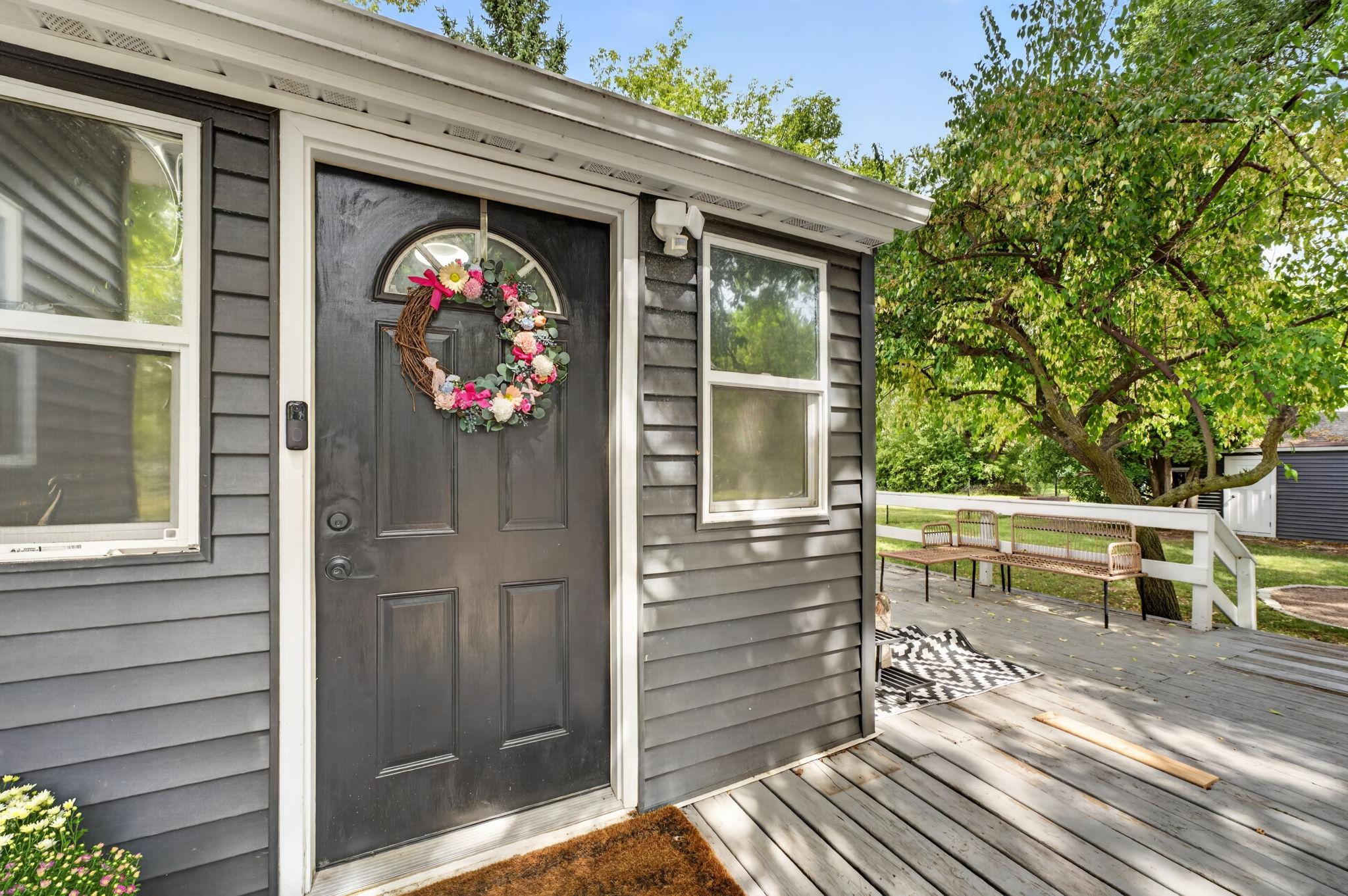 The home's primary entrance opens onto a large deck, creating a welcoming space for everyday living and entertaining.