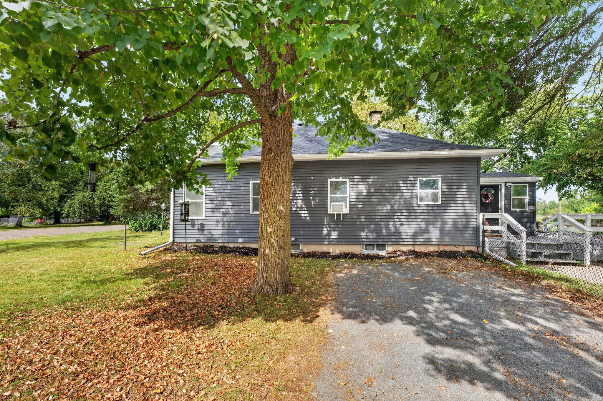 Spacious yard shaded by mature trees.