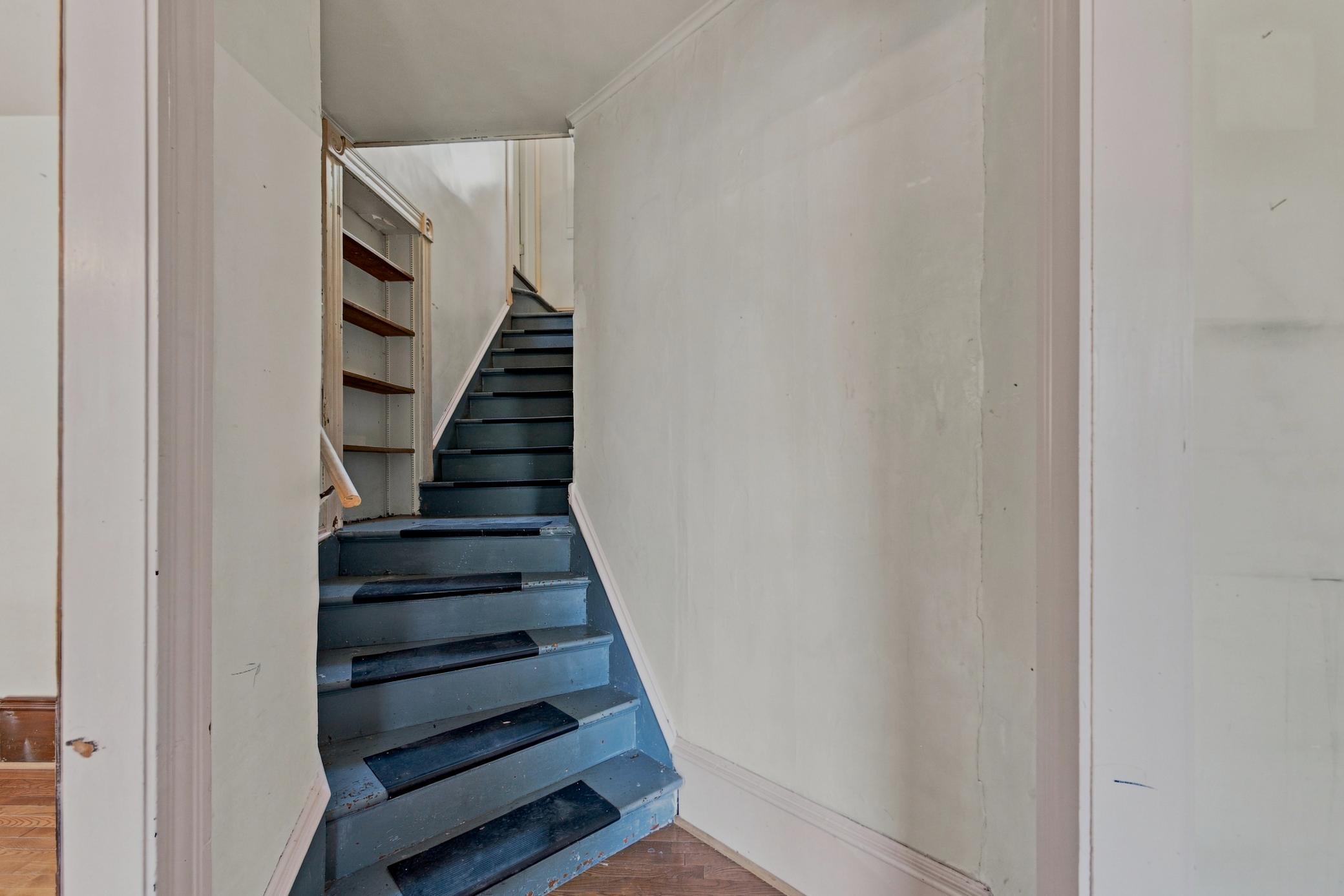 Winding staircase to second level with storage