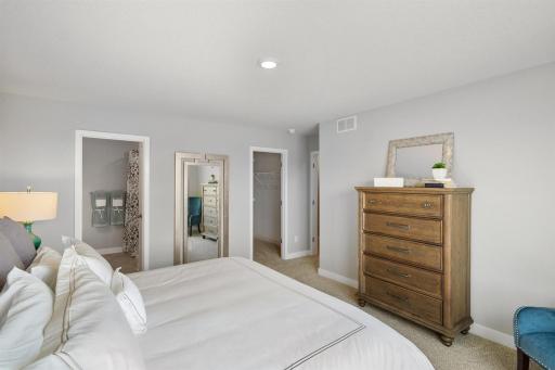 Primary bedroom with on suite and large walk-in closet. Pictures of model home colors and options will vary.