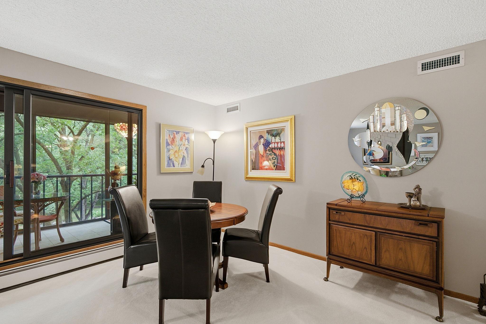 Informal Dining/Meeting Area - Multi-use area offers plenty of room for entertaining and enjoys a beautiful wooded view through the adjoining sunroom.