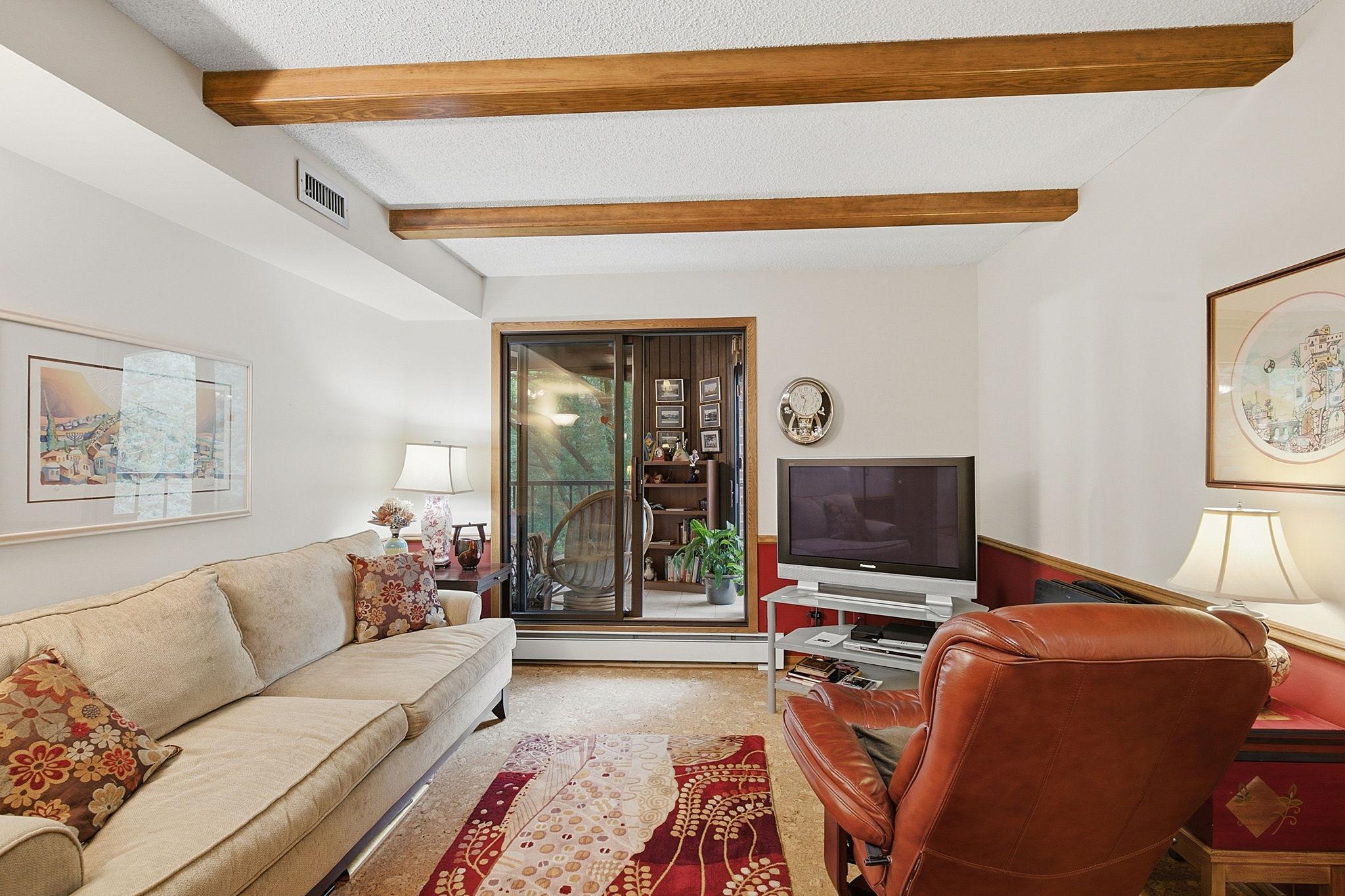 Bedroom 2/Den/Office - Comfortable additional living space with exposed ceiling beams and direct access to the screened balcony. A flexible room for relaxing, hobbies, media, guest bedroom, or a home office.